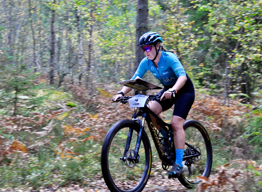 Karin E Gustafsson cyklar genom skogen i Haninge.