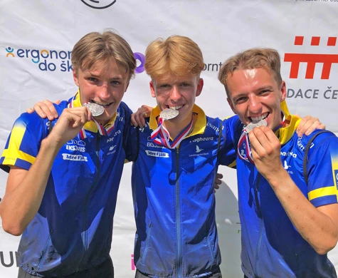 Svante Selin, Axel Bratt och Edvin Nilsson biter i sina silvermedaljer efter JVM-stafetten.