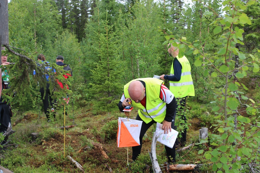 Jan stämplar i skogen tillsammans med andra O-Ringendeltagare.